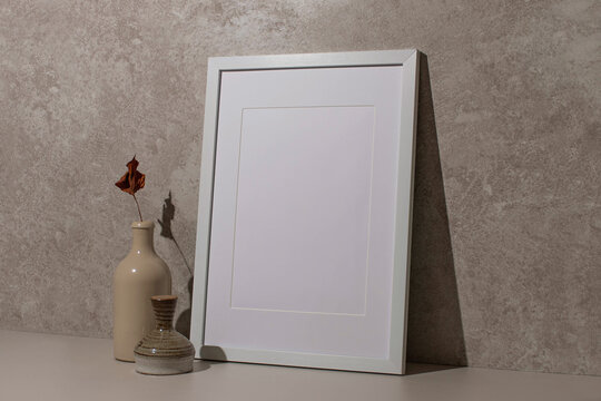 Blank empty mock up art paper picture frame sheet on marble granite with shadow, vase and flower