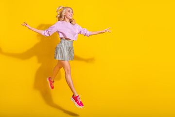 Full length profile portrait of cheerful energetic person run look empty space isolated on yellow color background