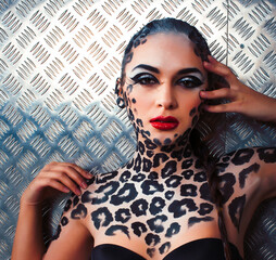young sexy woman with leopard make up all over body, cat bodyart print closeup