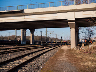 Freight station, rails and wagons with bulk cargo under a bridge. Transportation and logistics of various goods. 