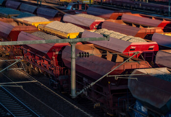 Fototapeta premium Freight station, rails and wagons with stones and gravel bulk cargo in Frankfurt am Main. Transportation and logistics of various goods. 
