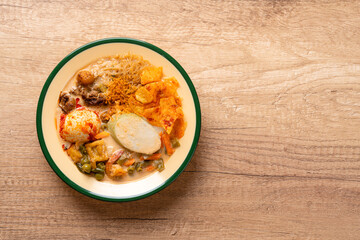 Lontong sayur or vegetable rice cake is an Indonesian traditional rice dish made of pieces of lontong served in coconut milk soup with shredded chayote, tempeh, tofu, hard-boiled egg, sambal, rendang