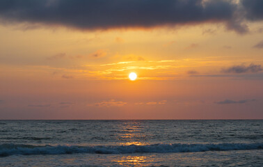  Bright beautiful sunset at the calm sea. Solar disk over water.