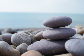 Fototapeta na wymiar Smooth purple pebbles stacked on pebbly beach in Cornwall