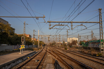 Fototapeta na wymiar Train tracks and power pylons at a Spanish train station near Barcelona. rails and sleepers close up.