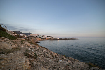 Obraz premium Picturesque sea evening landscape. Sunset over the mediterranean sea. Evening city, sea and sunset. The sun is above the horizon line.