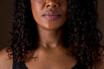 Close up portrait of african american woman features and soft dark caramel skin. Horizontal front view of unrecognizable woman lips and nose. People and diversity concept.