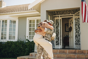 Happy soldier reuniting with his wife at home