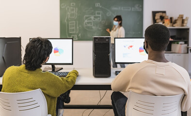Young students listening a lesson in high school while wearing face mask 