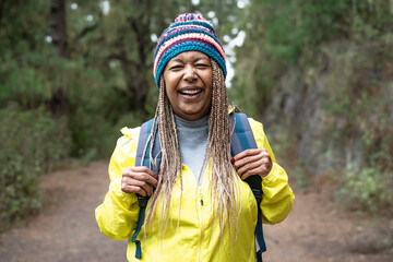 Happy Afro senior woman having a walk in the woods - Adventure and travel people concept - 494897740