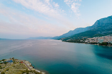 Panoramic top view of the sea and the modern resort town with high hotels near the rocky mountains.
