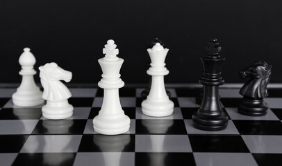 The king in a battle chess game stands on a chessboard with a black isolated background. Business Leadership Ideas.