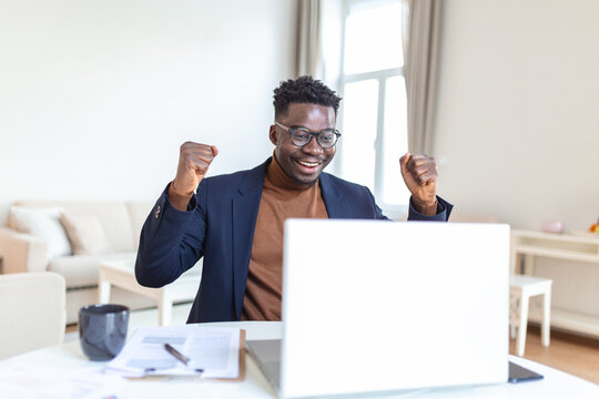 Excited African American Man Wearing Headphones Reading Good News In Email, Getting New Job, Promotion, Using Laptop, Looking At Screen And Screaming With Joy, Showing Yes Gesture, Celebrating