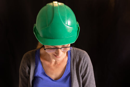 Woman Wearing A Green Hard Hat And Glasses Smiling