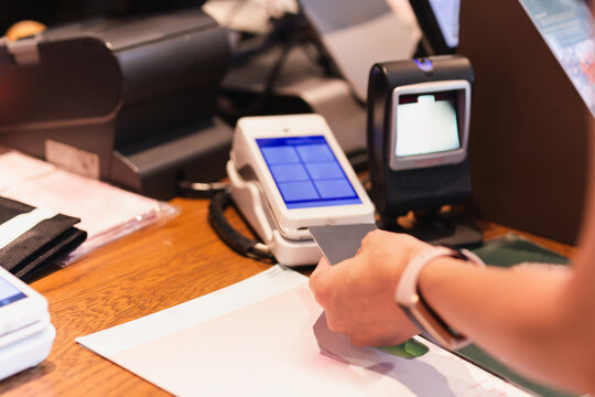 Woman paying bill at cafe by insert credit card in credit card reader.