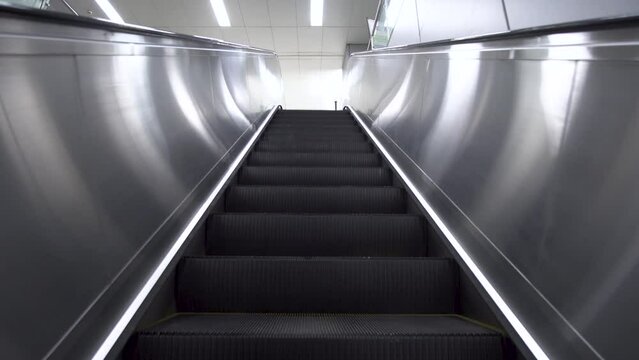 First Person POV empty moving up escalator on public place, downtown, empty moving up escalator on public place, downtown, city, subway. Low angle shot of escalator during pandemic, lockdown, COVID-19