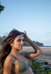 Fototapeta na wymiar Portrait of brunette woman in green bikini in a tropical pasadise beach