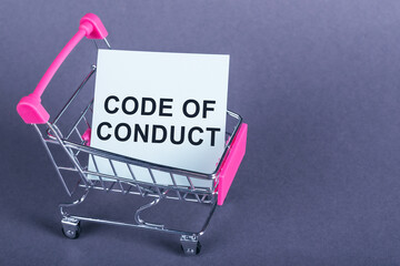 Top view of shopping cart and white card in it with Code of conduct text on purple background....