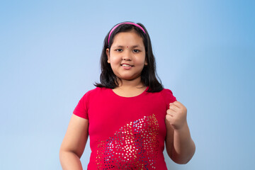 Indian girl In Success Pose isolated on a Blue background