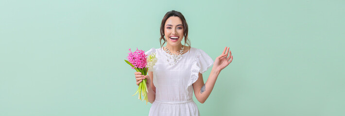 Happy young woman holding bouquet of hyacinth flowers on color background with space for text