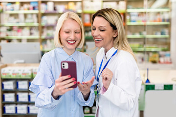 Professional pharmacist talking with customer in modern drugstore. The customer shows to the...