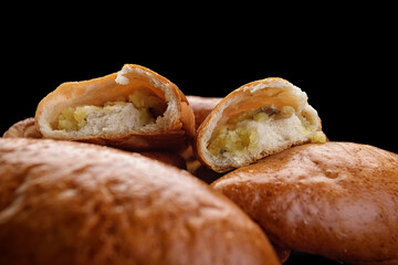 baked pies with potatoes on a dark background © pobaralia