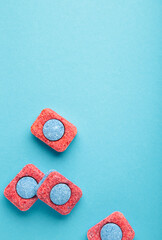 Red and blue tablets for dishwashing machine. Detergents for home hygiene. Dishwasher capsules on...