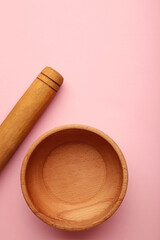 Wooden kitchen utensils on pink background.