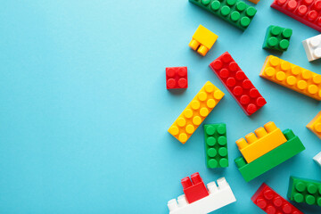 Multicolored blocks of the children's constructor lie on a blue background.