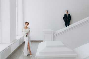 Wedding of a beautiful, stylish couple, a bride in a white wedding dress and a groom in a black...