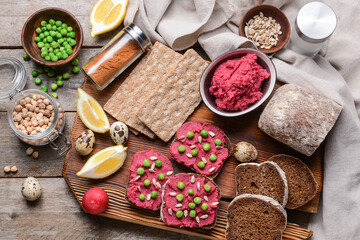 Crispbreads and bread with tasty hummus on wooden background