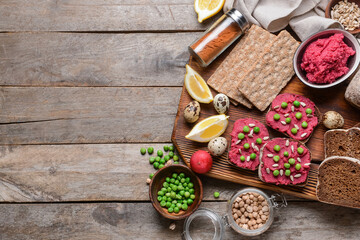Crispbreads and bread with tasty hummus on wooden background