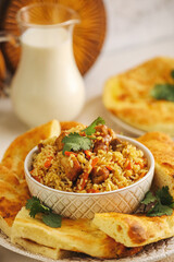 Bowl with tasty Asian pilaf and flatbread on tray