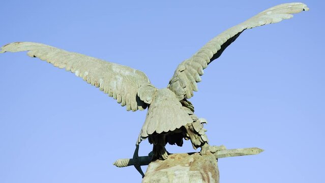 1 a metal monument to an eagle with outstretched wings with a sword in its claws