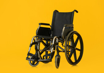 Fototapeta na wymiar Empty wheelchair on color background