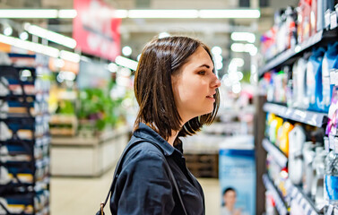 young woman looking at product at grocery store in supermakket. shopping