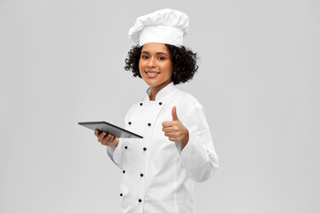 cooking, culinary and people concept - happy smiling female chef in toque and jacket with tablet pc...