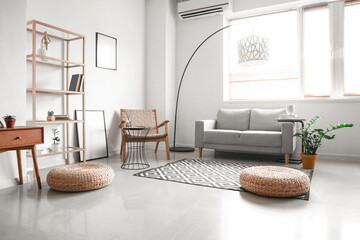 Interior of light living room with sofa, wooden armchair and standing lamp