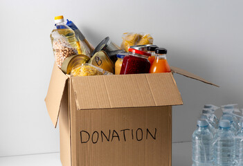 charity, support and concept - close up of food in donation box and water