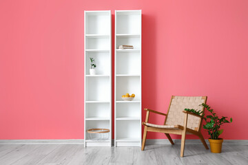 Interior of room with armchair and shelf units near color wall