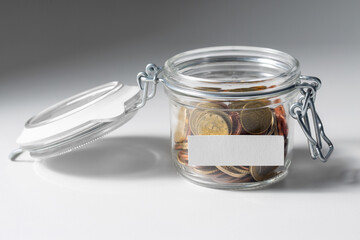 charity, donation and saving concept - close up of coins in glass jar