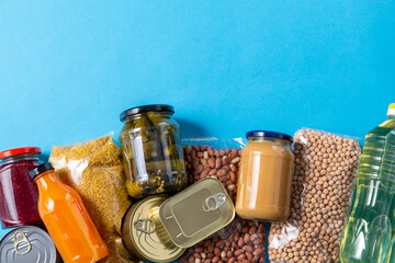 eating, charity and donation concept - close up of different packed food on blue background