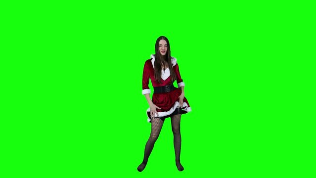 Slow motion of an attractive model in Christmas costume taking a spin in front of a green screen