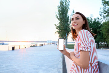 Young female tourist with phone outdoors