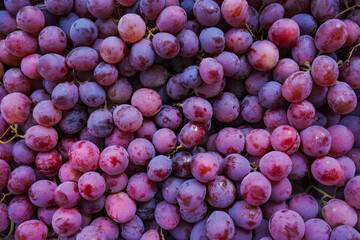 Close up of raw organic sweet red grapes background.
