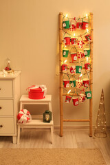 Advent calendar, Christmas decor and gift boxes near wall in room