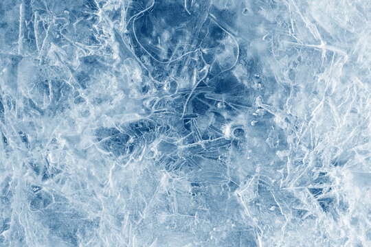 Ice background texture. Frozen water in various geometric abstract shapes. Seasonal natural effect. Cold weather. The surface of the winter water reservoir.