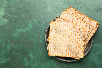 Dish with Jewish flatbread matza for Passover on green background