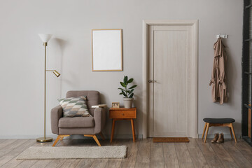 Interior of modern room with standing lamp, armchair and table