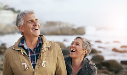 Weve always shared the best laughs together. Shot of a beautiful elderly couple taking a walk at the beach.